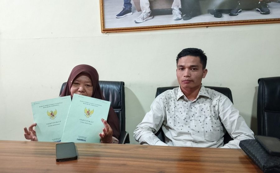 Sumini, warga yang berhasil menuntuk hak pesangon, menunjukkan sertifikat yang sempat tertahan.